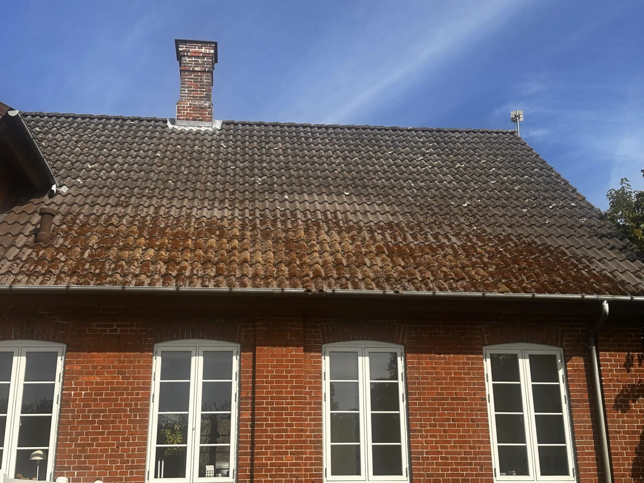 Roed murstensfacade med hvide vinduer